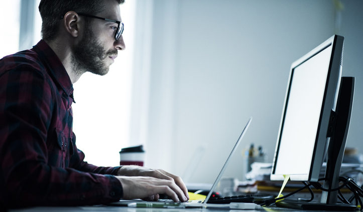 Man working on his computer reads content collections