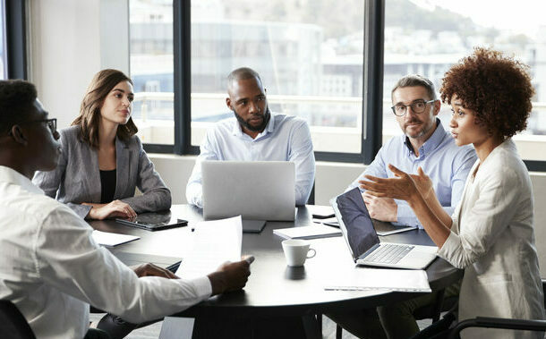 The right knowledge management system can make you the smartest person in the room- Millennial black businesswoman addressing colleagues at a corporate business meeting, close up