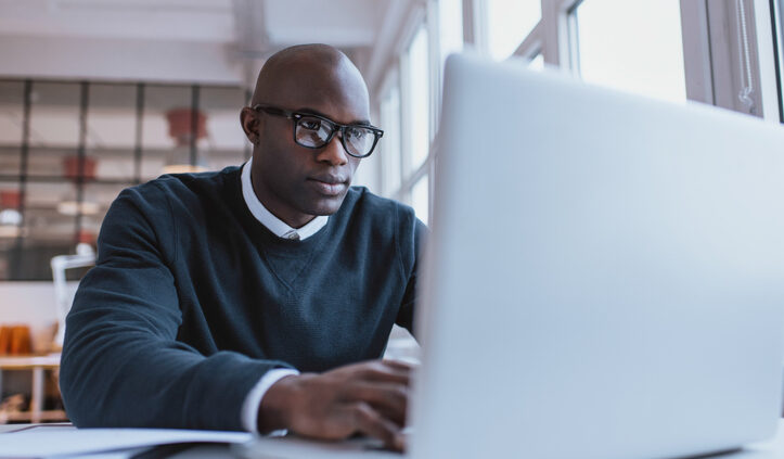 Young businessman working on his laptop. Consumer insights