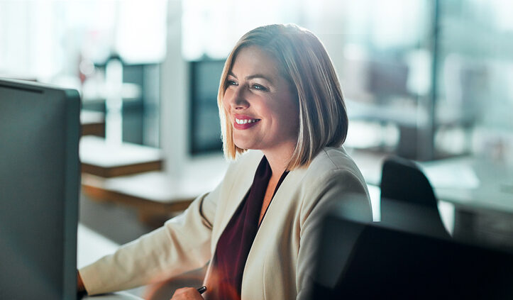 Woman with a bob haircut and galsses works at a laptop. IBM on being strategic with AI.