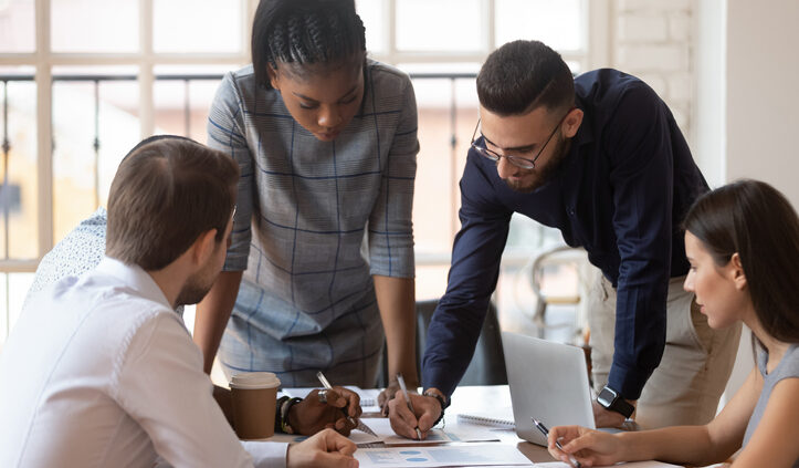 Focused corporate business team people collaborate around a table. Consumer packaged goods can drive resilient growth.