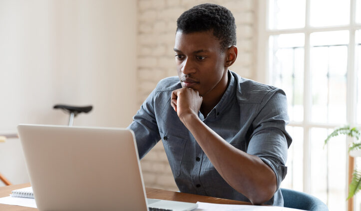 Young Black man concentrates on his laptop. SinglePoint out googles search