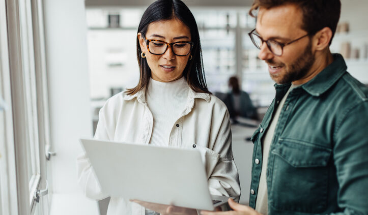 In conversational AI, last month seems like a decade ago, given how quickly the market and technology is evolving. Business professionals standing in an office and using a laptop.