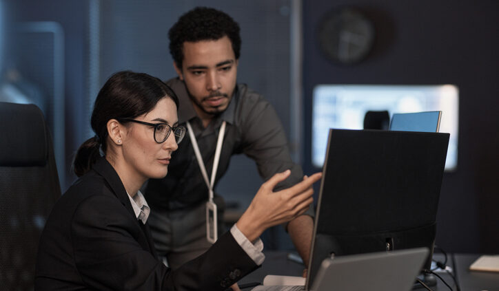 Senior project manager pointing at computer screen while reviewing code. Generative AI and marketing and competitive intelligence research